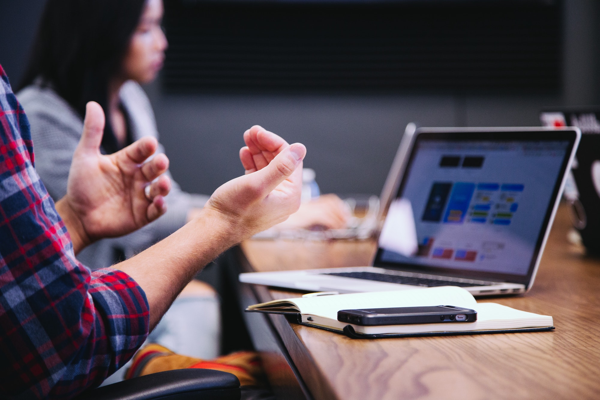 Business meeting with a man on his laptop gesturing with hands