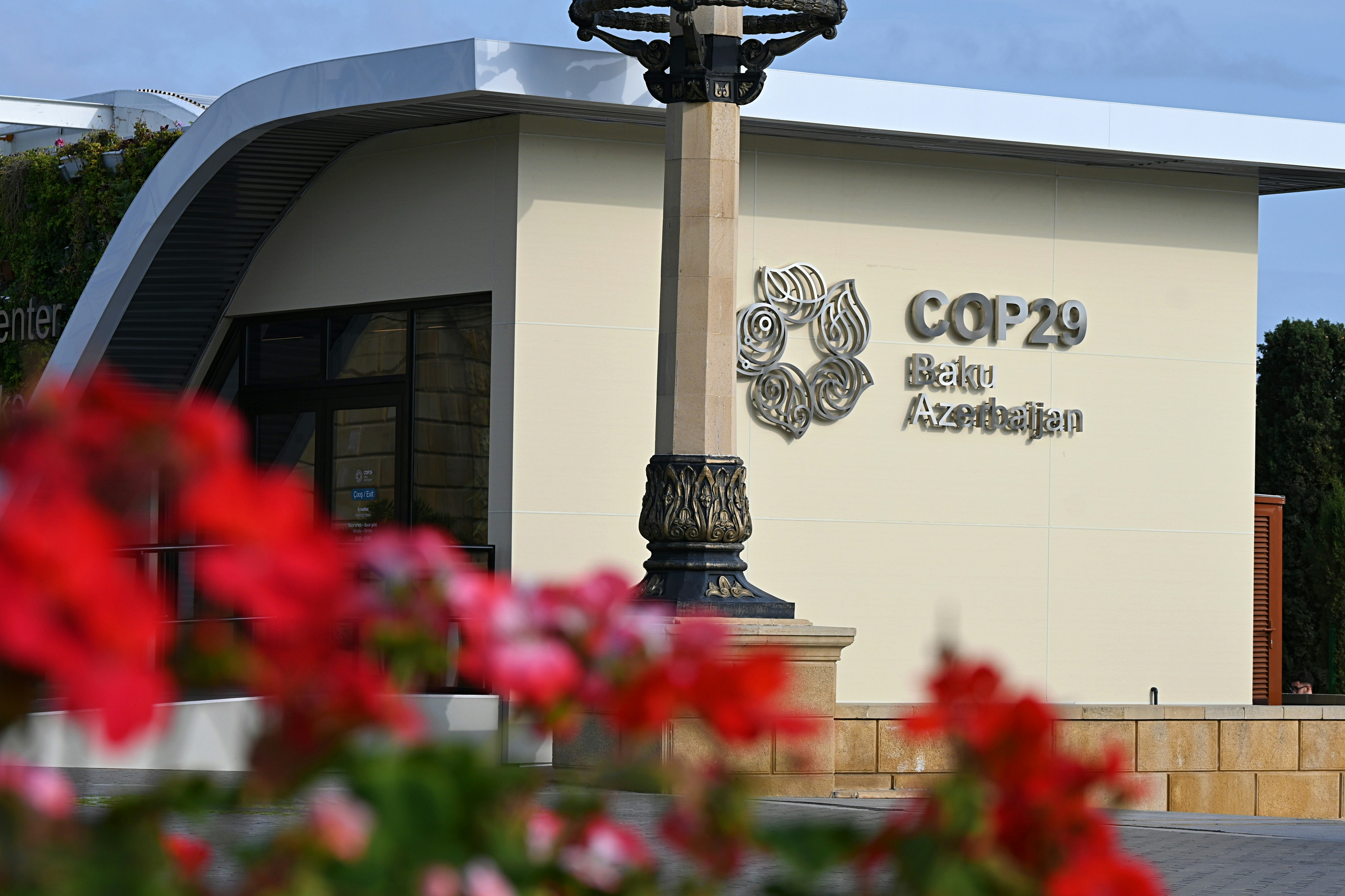 Photo of COP29 sign in Baku with flowers in foreground